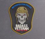 Veterans Day 2025 MPDC Badass Veteran PVC patch collection with glow-in-the-dark text featuring tactical skull design and American flag background with saluting soldiers silhouette