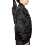 Woman wearing a navy blue 1221-JW Bravest Ladies Fit Quilted Jacket with ribbed collar and cuffs, designed for female first responders.