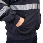 Man wearing a navy 9450 Commander Bomber Jacket with reflective stripes on chest and sleeves, fleece collar, and ribbed cuffs—designed for first responders.